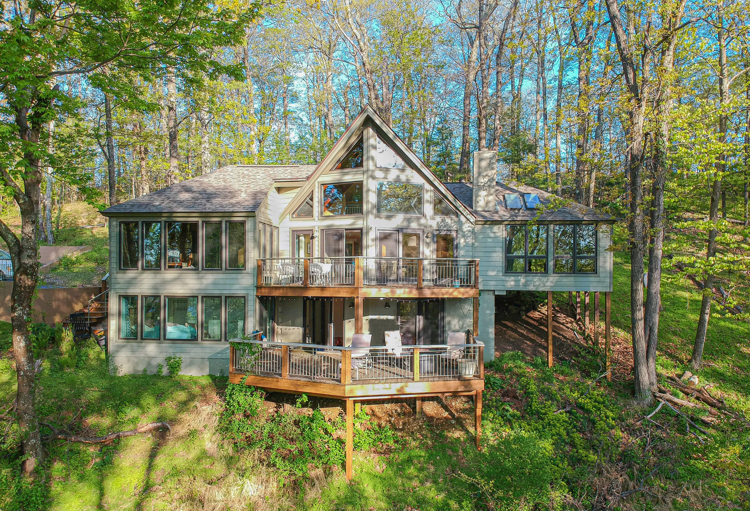 Little Bear, an A-frame house with two decks, seen from above through spring trees