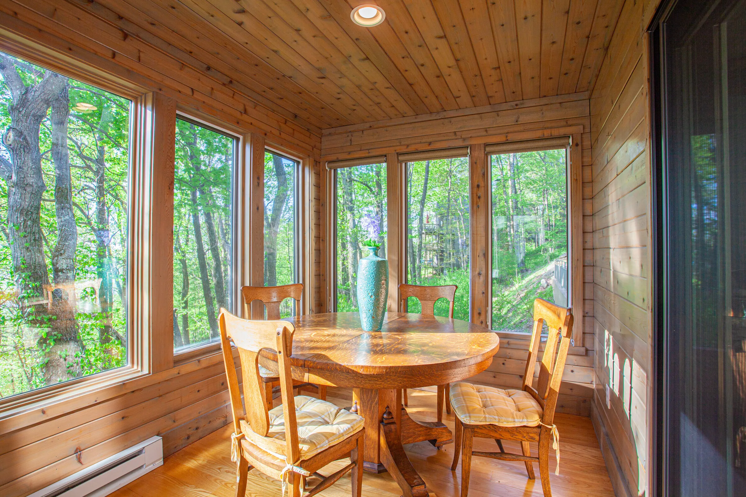 Sunroom with dining table surrounded by windows